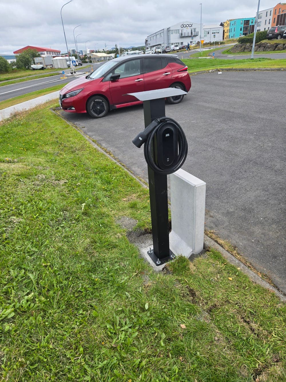 Hleðslustöð við vinnustað, rafbíll í stæði við hliðina